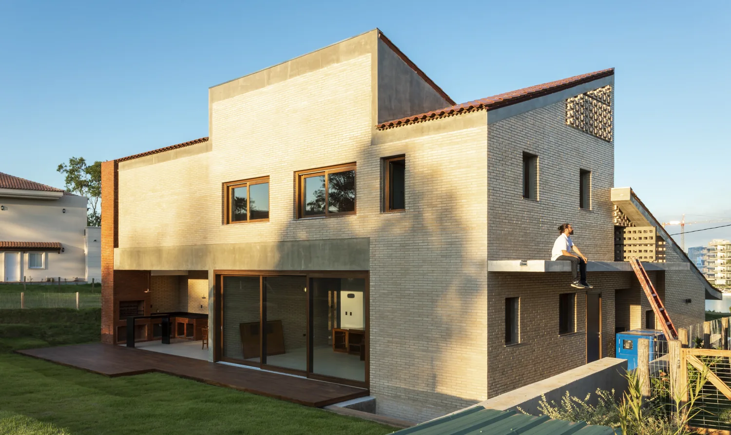 Fachada lateral de Casa Naciente con grandes ventanales de madera
