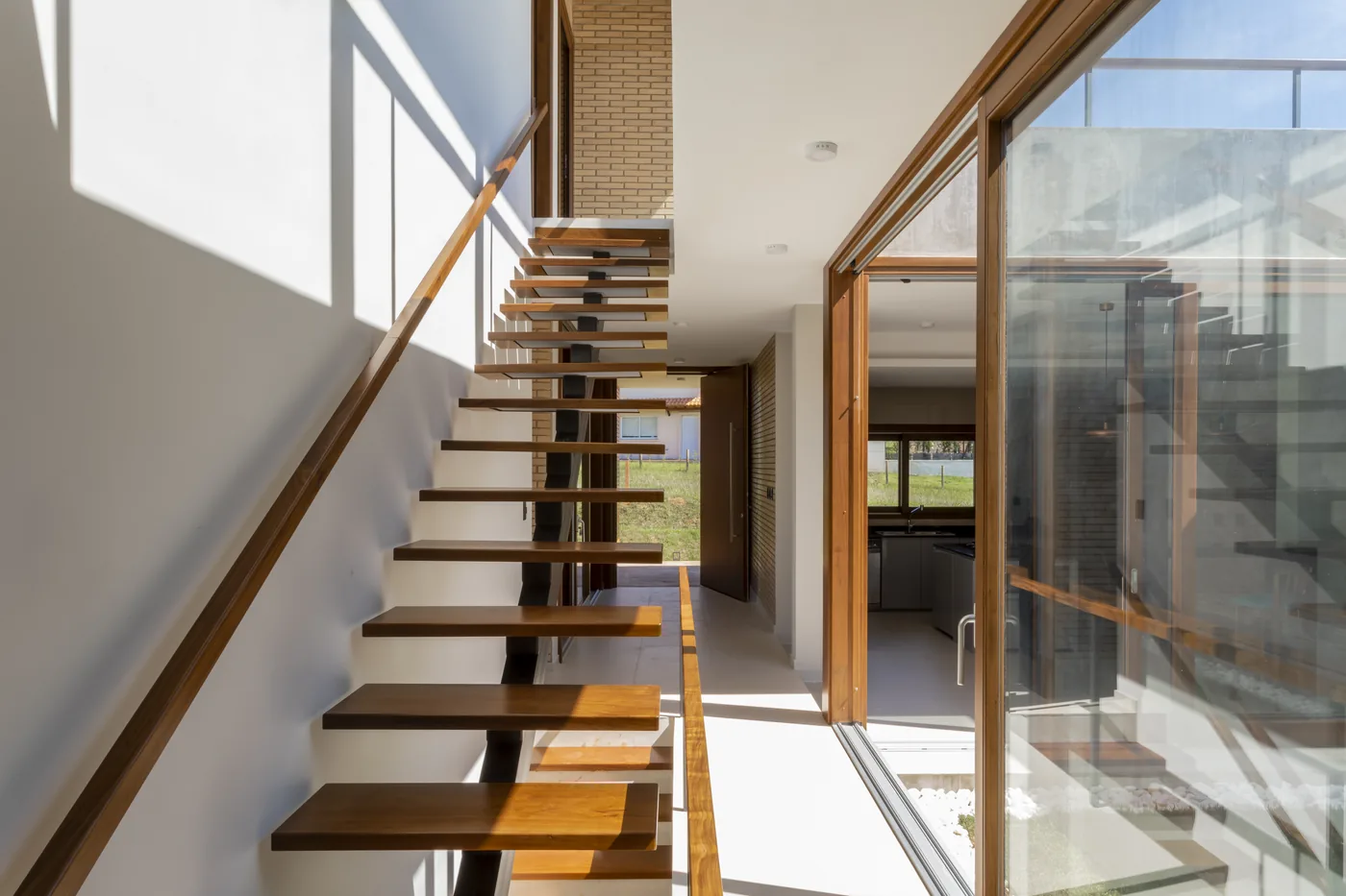 Escalera interior de Casa Naciente junto al ventanal de madera